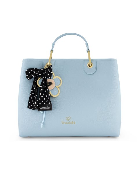 The Beth Blue Charm Tote Bag: a pale blue tote with a black polka-dot ribbon and daisy charm on its handle.