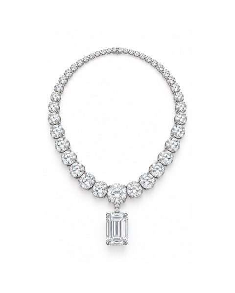 A clear rectangular pendant suspended from a necklace of round stones.